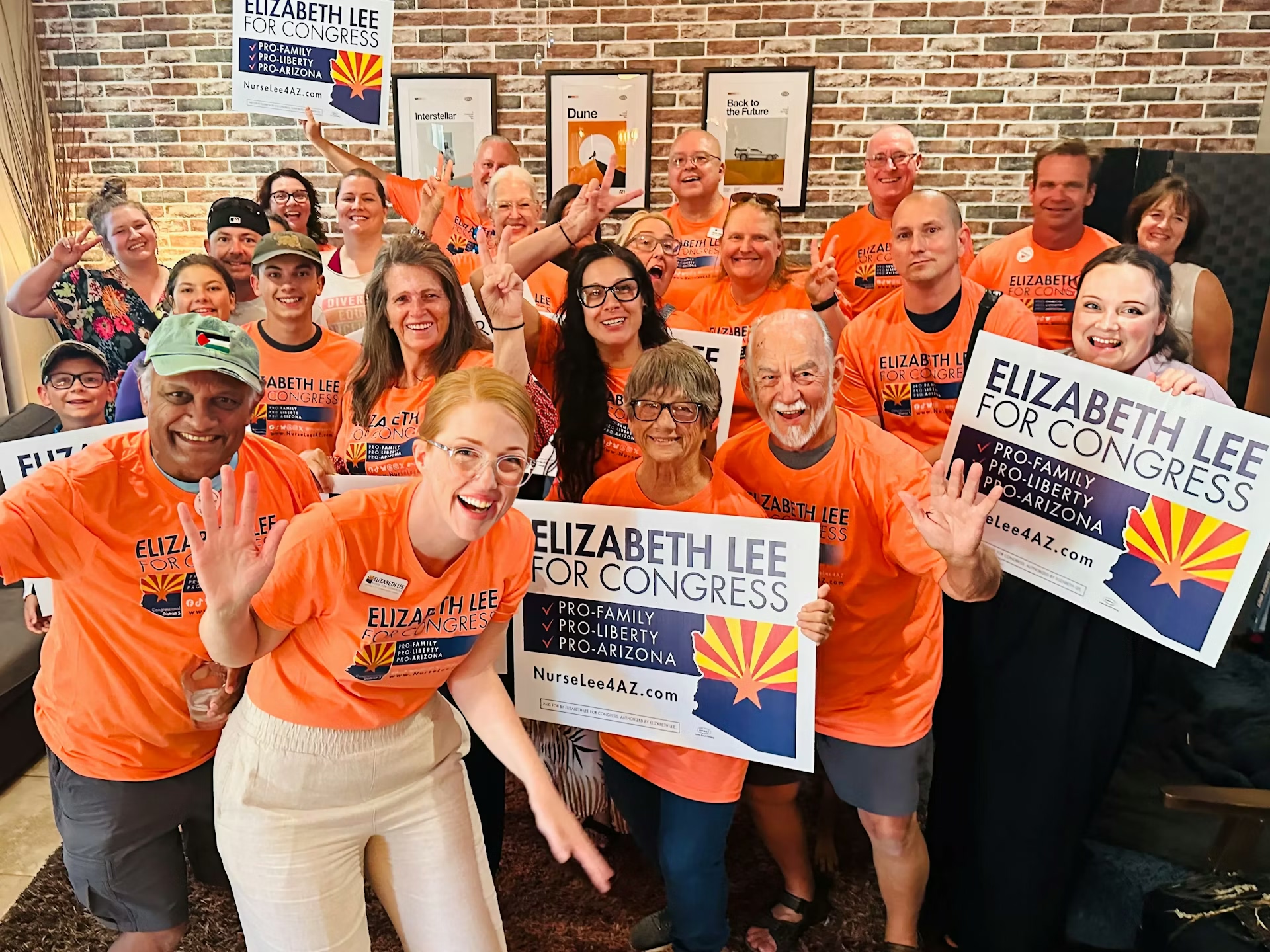 photo of Elizabeth Lee with volunteers in campaign t-shirts and holding signs